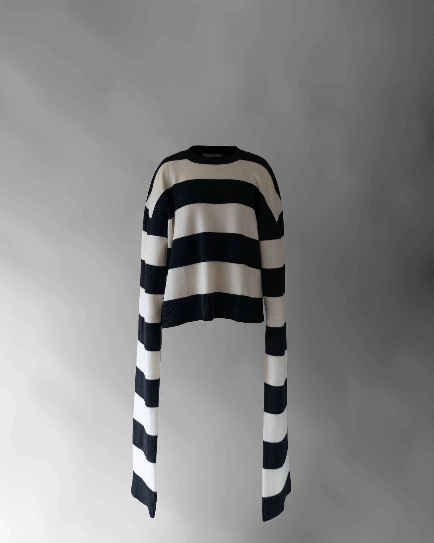 front photo of notebook sweater, a black and white striped sweater with very long sleeves floating on a light grey background.